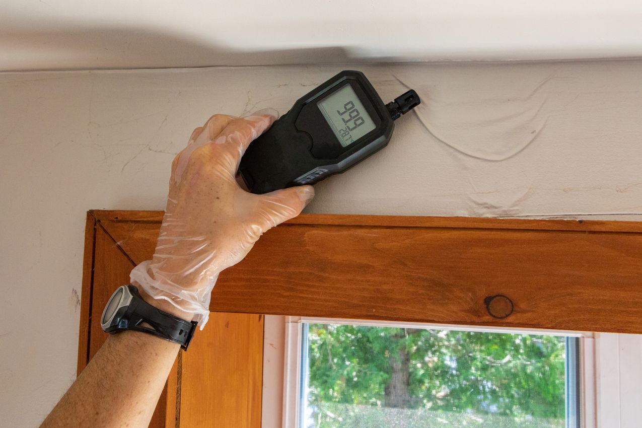 Indoor damp & air quality (IAQ) testing. A close up view of an indoor environmental quality assessor using a handheld digital device with lcd numeric display during a residential dwelling check up. technicien VMC fait un diagnostic