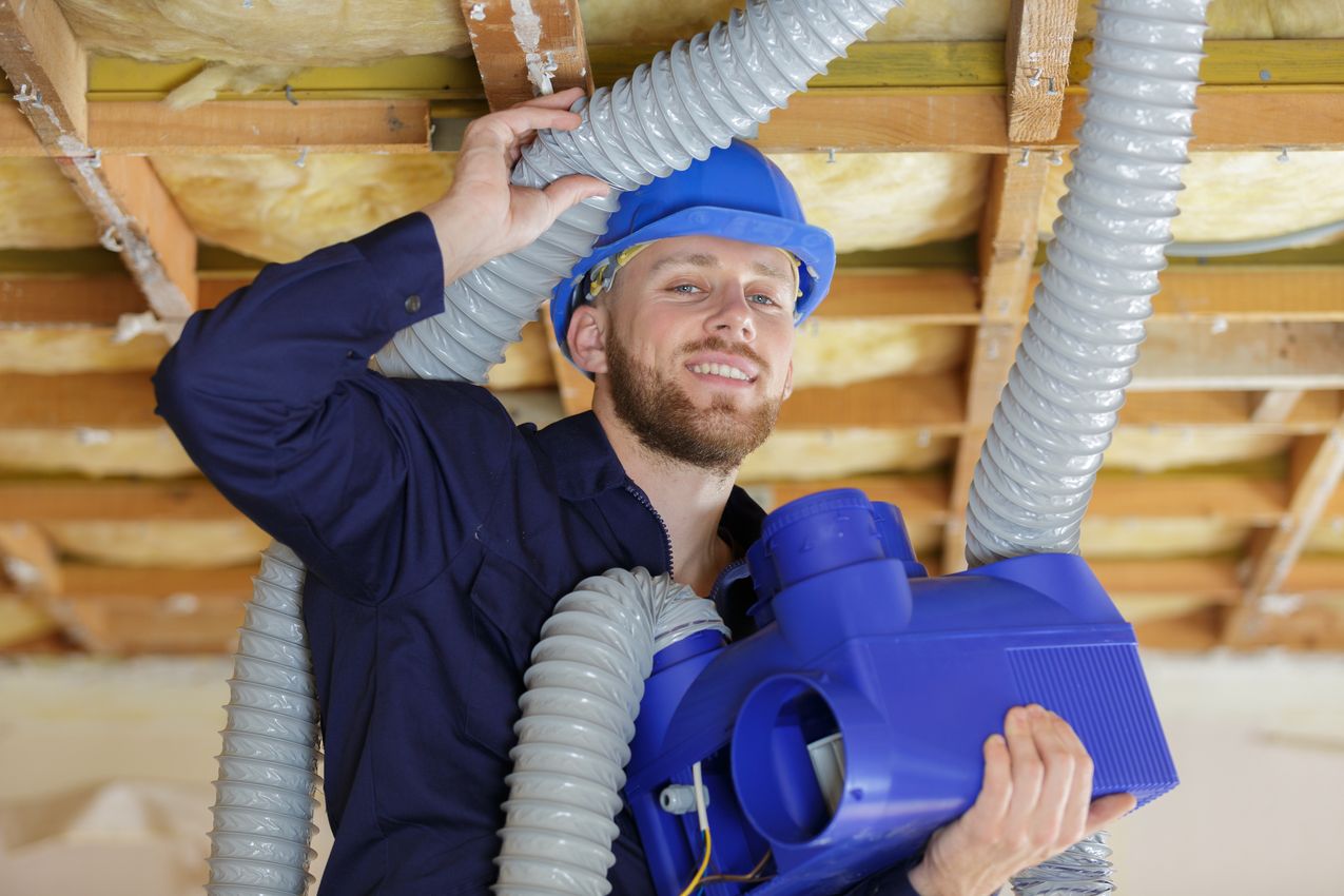 male builder working with pipes homme installe une vmc simple flux