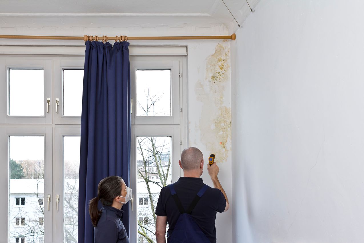 Homme qui mesure l'humidité dans un appartement avec de la moisissure problème humidité dans un appartement a cause de la VMC et son manque d'entretien