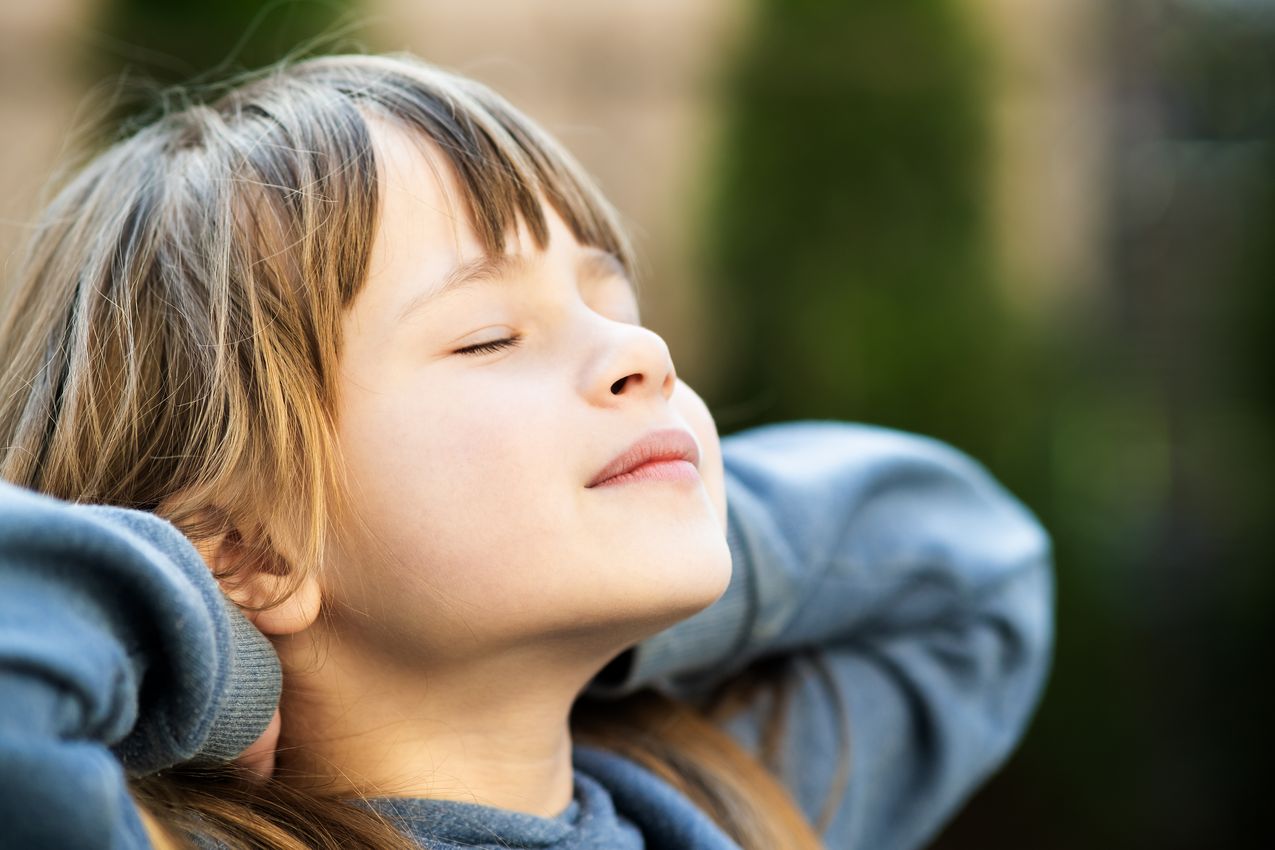 Portrait of young pretty child girl with long hair enjoying warm sunny day in summer outdoors. Cute female kid relaxing on fresh air outside. Jeune fille respirant un air pur dans une salle bien ventilée – VMC pour école et crèche