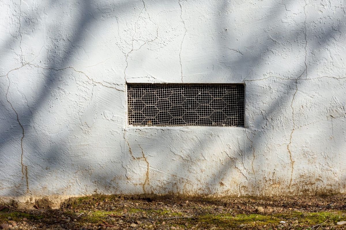 Grille d'aération de vide sanitaire dans un mur de soubassement