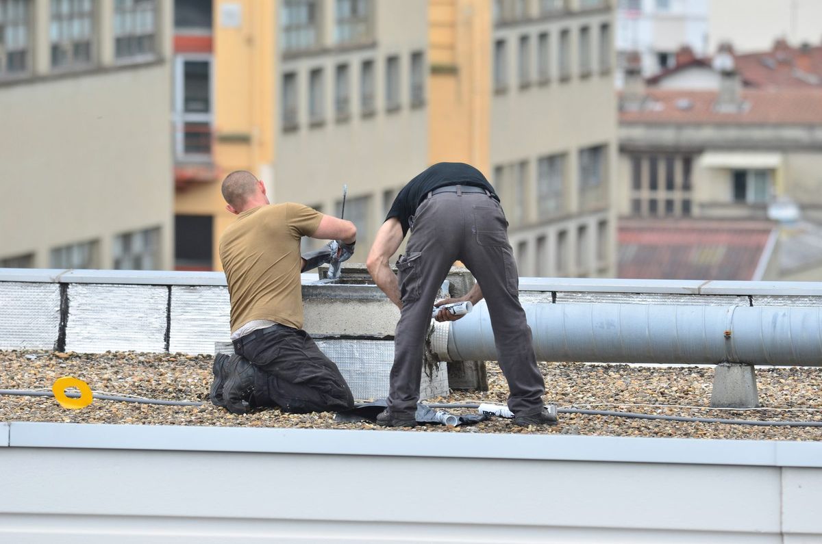 Techniciens intervenant sur la VMC collective en toiture d'un immeuble