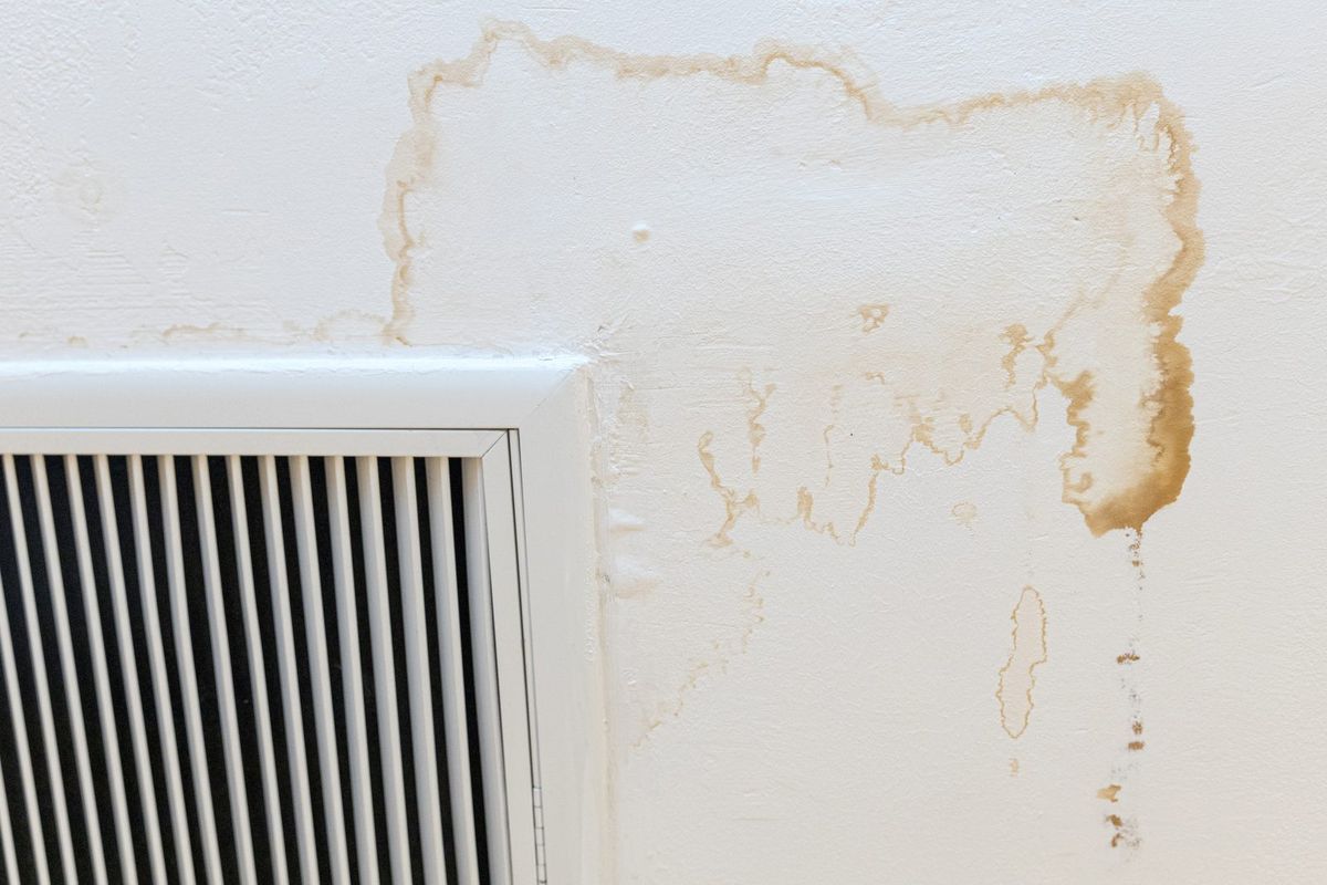 Tache d'humidité au plafond autour d'une bouche de ventilation
